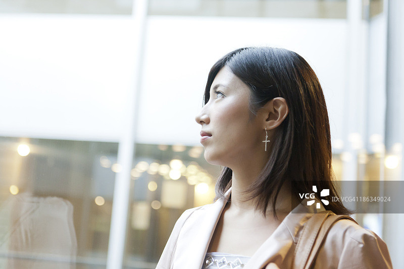 透过窗户看东西的年轻女人图片素材