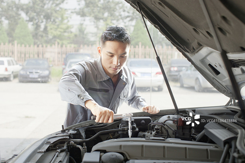 在车库修理发动机的机修工图片素材