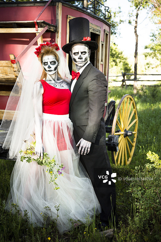 人物：骷髅新娘和新郎摆出怪异的婚礼姿势。图片素材