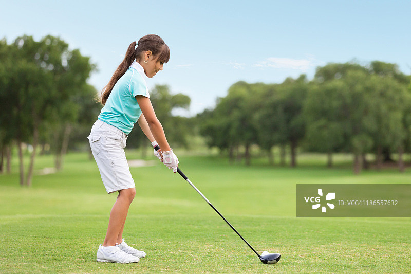 年轻高尔夫球手在球场上开球图片素材