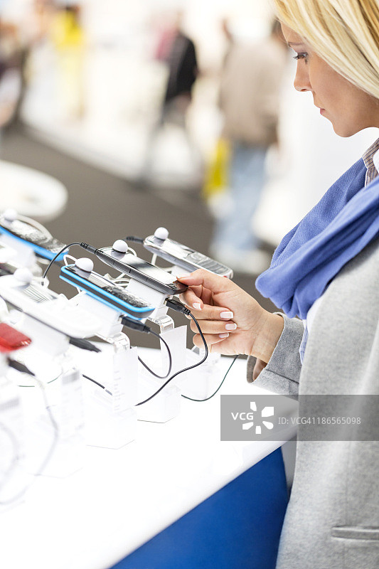 女性在手机店体验智能手机图片素材