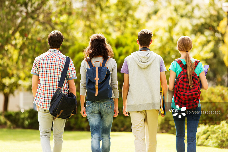 后视图-一群学生在校园里行走图片素材