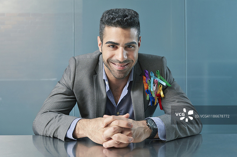 在办公桌旁，翻领上戴着丝带的商人图片素材