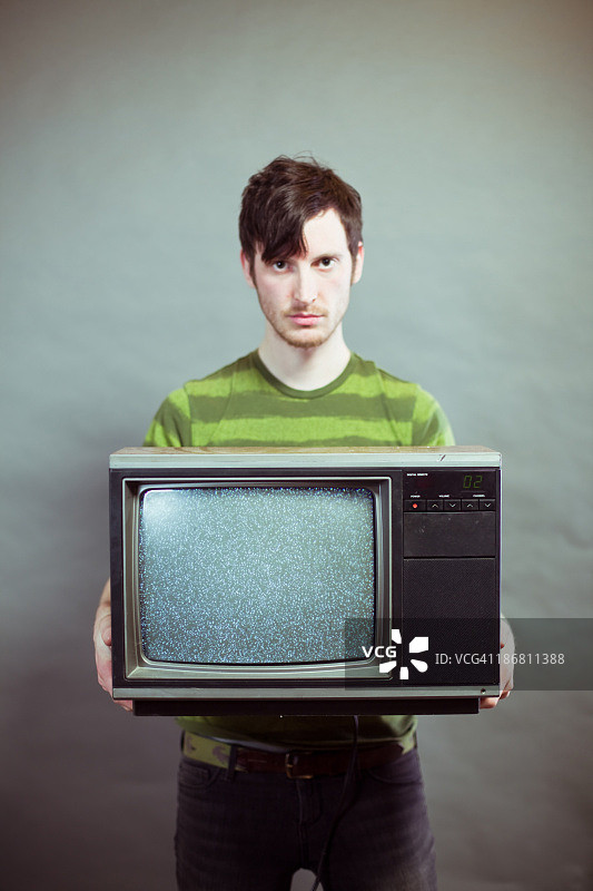 拿着静态电视的阴郁年轻人图片素材
