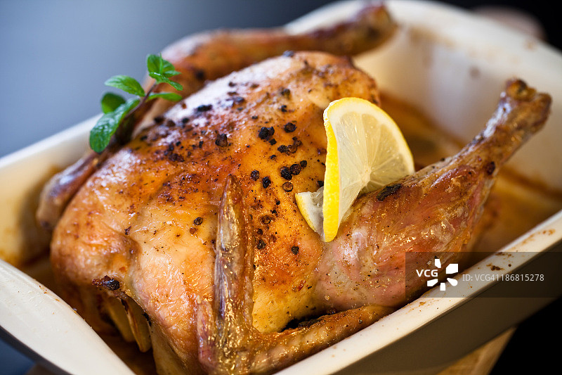 柠檬薄片和薄荷装饰的烤全鸡图片素材