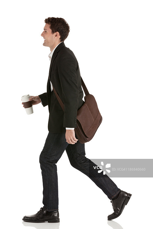 喝着咖啡行走的快乐商人图片素材
