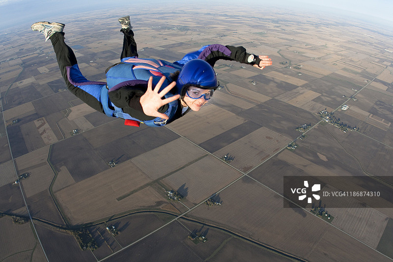 年轻女人在跳伞时向空中挥手图片素材