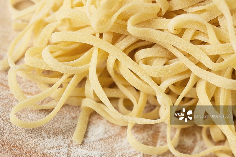 木头上的新鲜未烹饪细面条图片素材