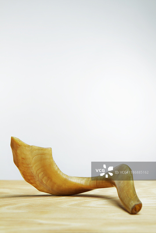 白色墙壁前木桌上的羊角号图片素材