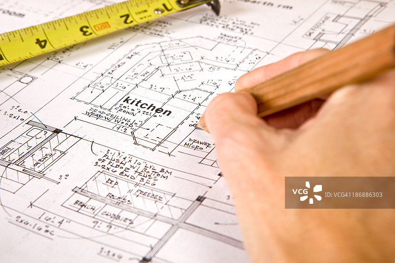女性手持木工铅笔在带有卷尺的图纸上图片素材