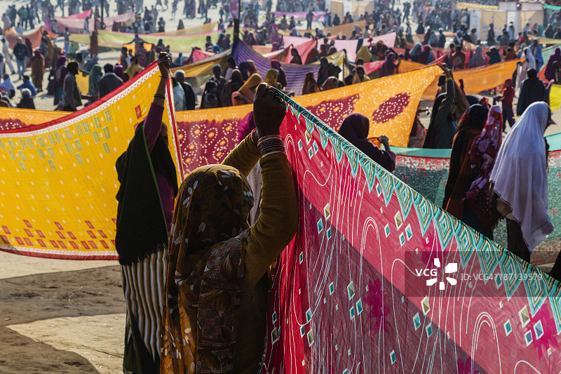 在印度北方邦阿拉哈巴德的节日上，妇女拿着彩色布料图片素材