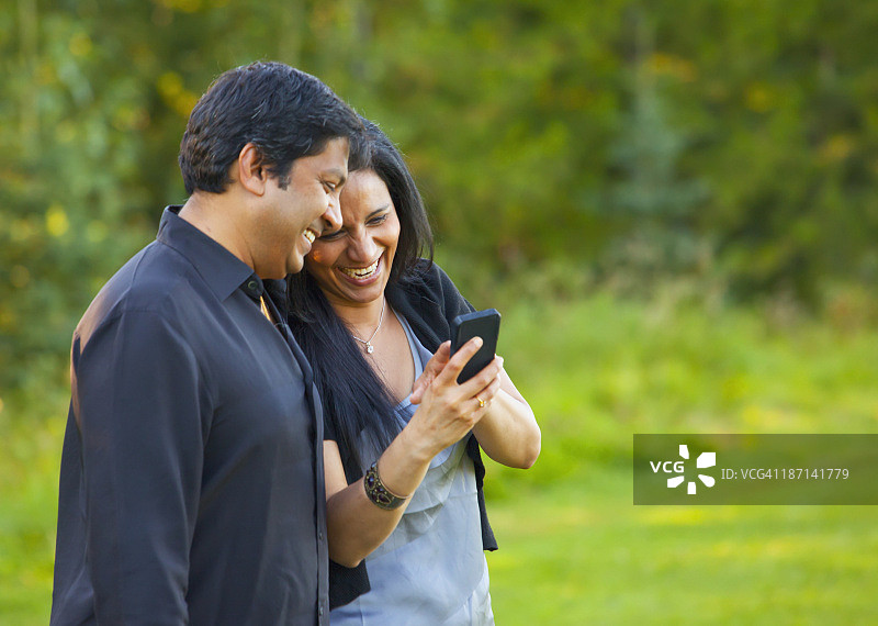 情侣一起看手机，开怀大笑图片素材