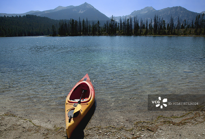 一艘孤独的皮划艇停靠在原始湖岸边图片素材