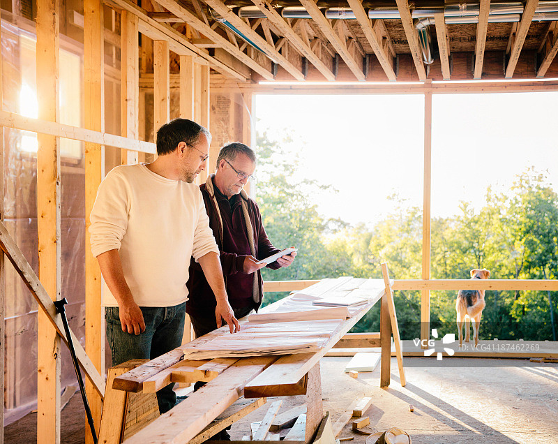 建筑师将纸质设计图与平板电脑版本进行比较图片素材