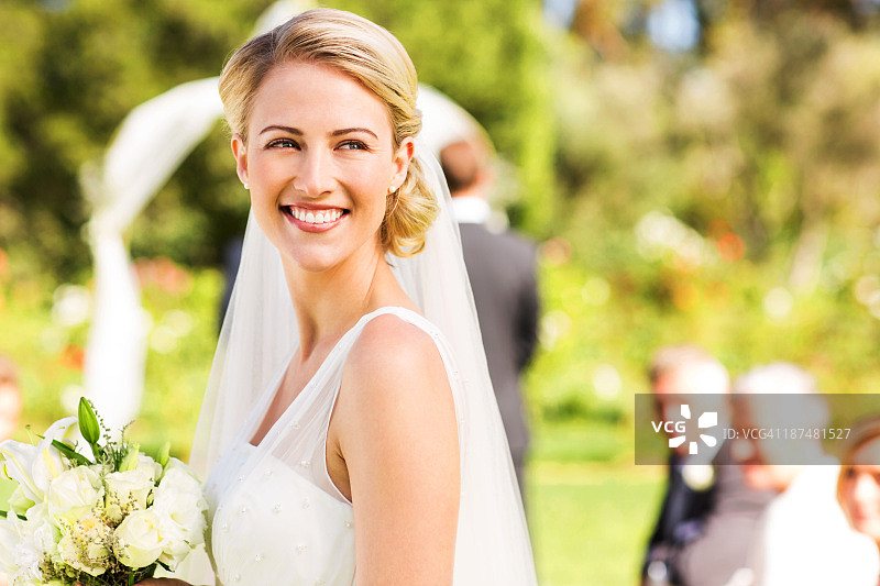 花园婚礼上看向远方的美丽新娘图片素材