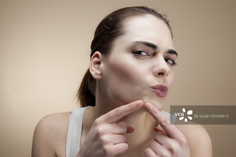 年轻女人专注挤痘痘图片素材