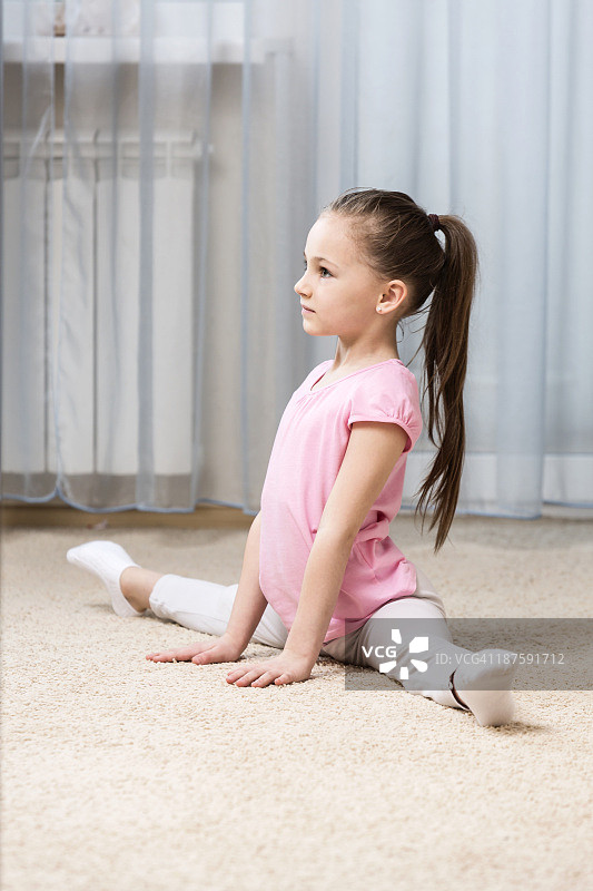 芭蕾舞女孩在卧室里做劈叉图片素材