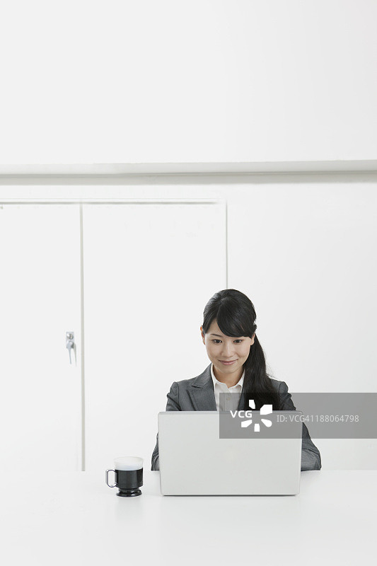 商务场景：使用笔记本电脑的20岁女性图片素材