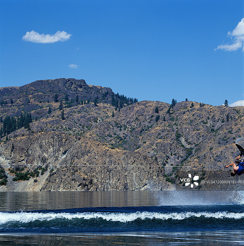 男子在湖上玩尾波跳跃（侧面视角）图片素材