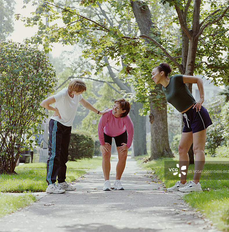 三个女人在人行道上伸展和休息图片素材
