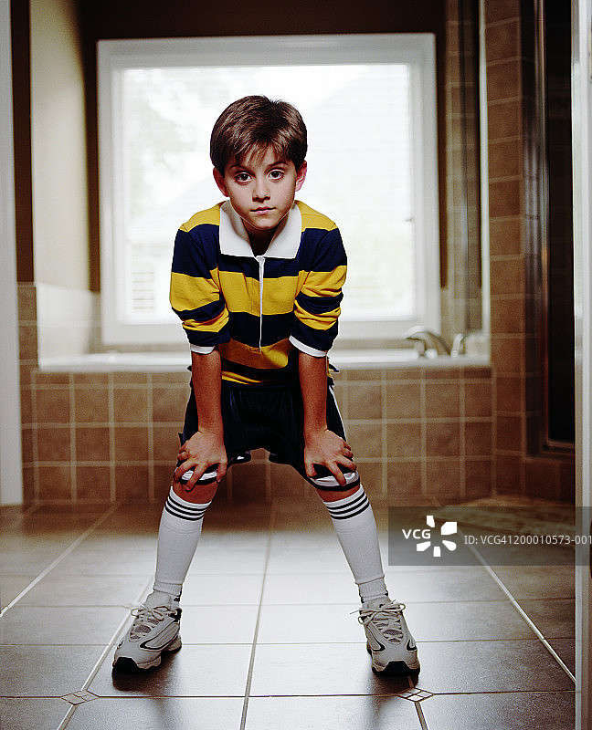 穿足球队服站在浴室里的男孩（8-10岁）图片素材