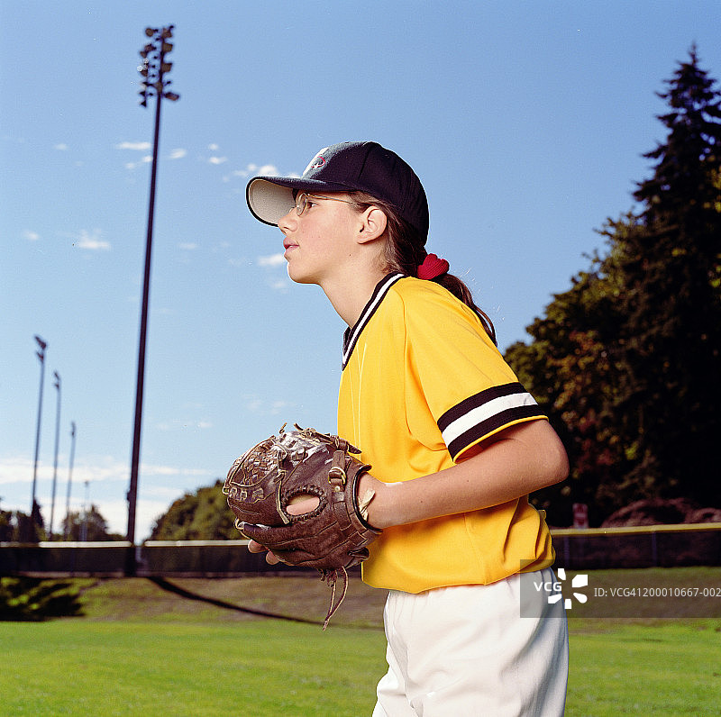 身穿棒球服站在外野的年轻女孩图片素材