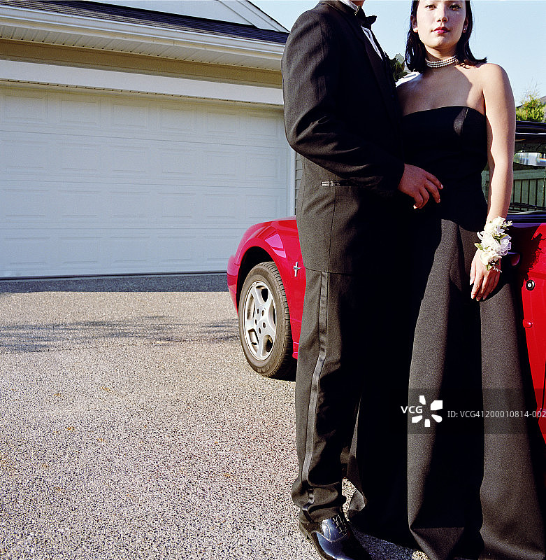 高中毕业舞会前站在车旁的毕业生图片素材