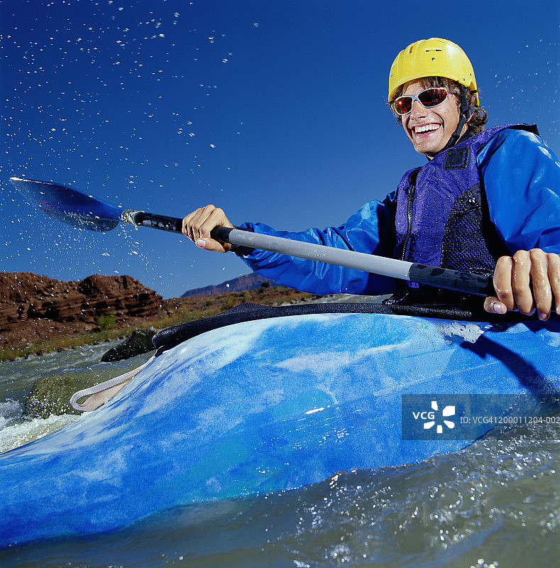 年轻男子白水皮艇，科罗拉多河，摩押，美国犹他州图片素材