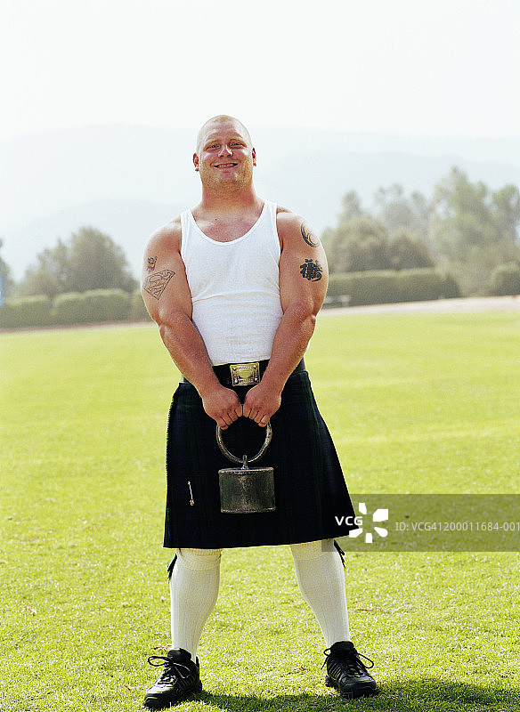 高地运动会：选手举起投掷物图片素材