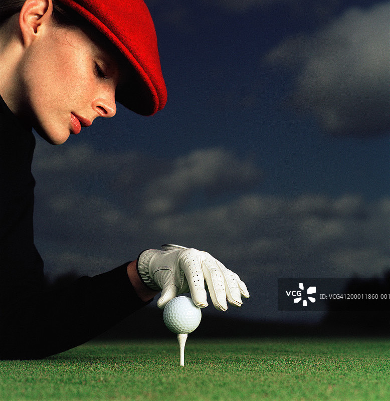 女高尔夫球手放置球，特写图片素材