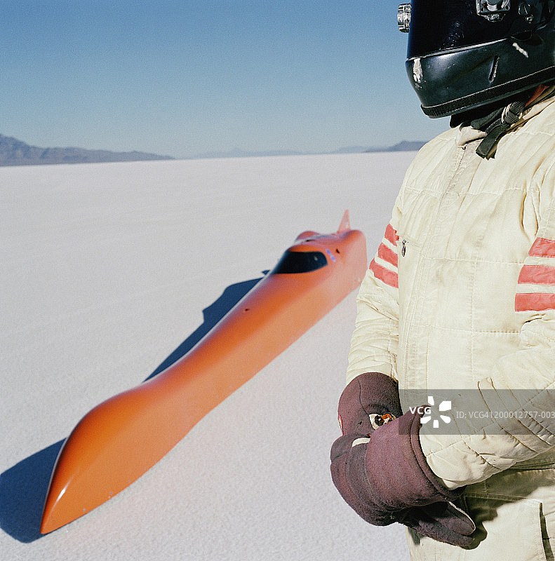 赛车手站在流线型赛车旁（选择性聚焦）图片素材