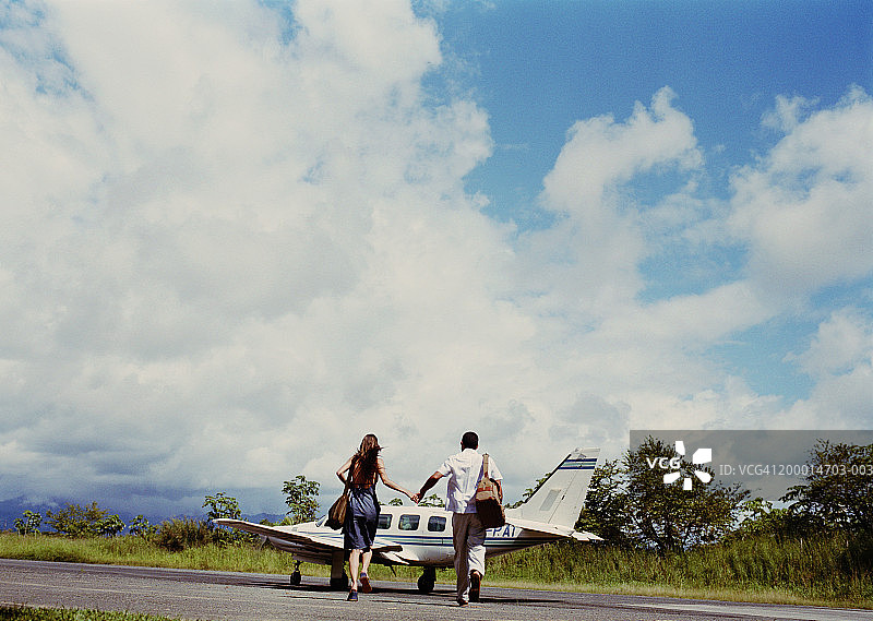 情侣走向飞机，后视图图片素材