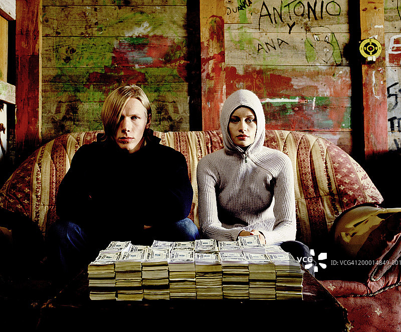 年轻情侣与一堆纸币合影图片素材