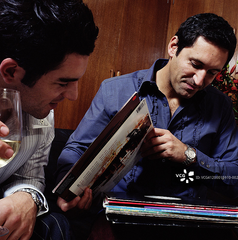 两名男子查看唱片，特写镜头图片素材