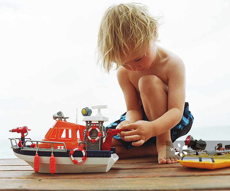 玩玩具船的男孩，特写图片素材
