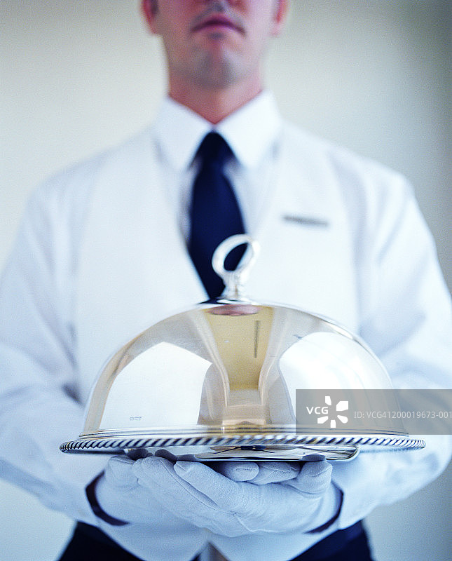 服务员戴着白色手套，端着银盘图片素材