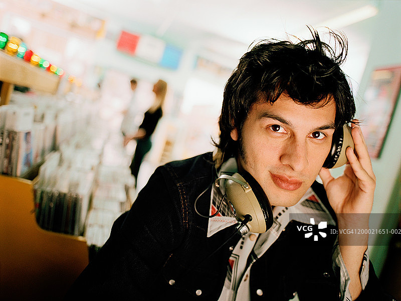 在唱片店听音乐的年轻男人图片素材