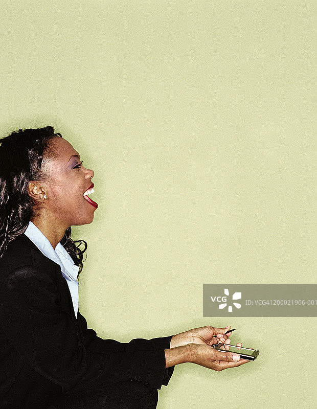 使用掌上电脑的年轻女人侧面照图片素材