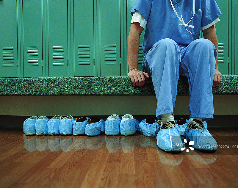 在更衣室穿鞋套的医务人员（局部）图片素材