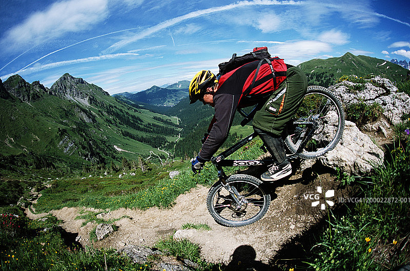 瑞士尚佩里：男子在崎岖地形上骑山地自行车图片素材