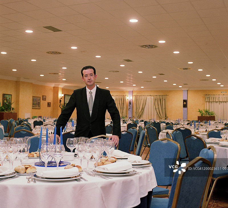 宴会厅空桌旁边的餐厅领班图片素材