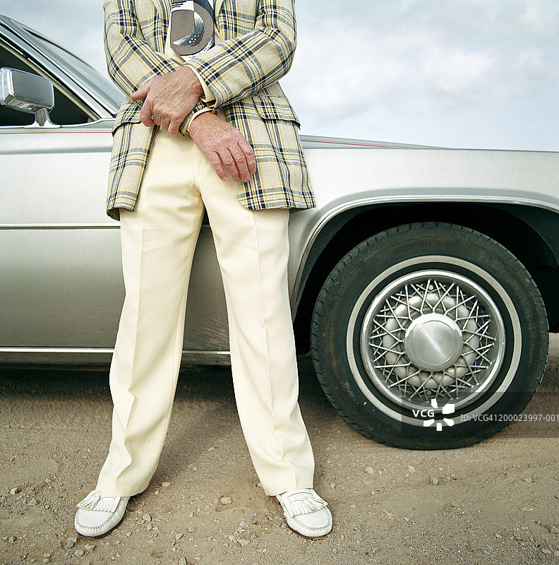 穿西装的男人靠在车旁（下半身）图片素材
