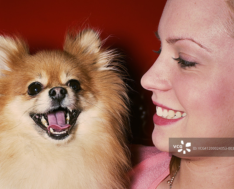 年轻女子和小博美犬的肖像图片素材