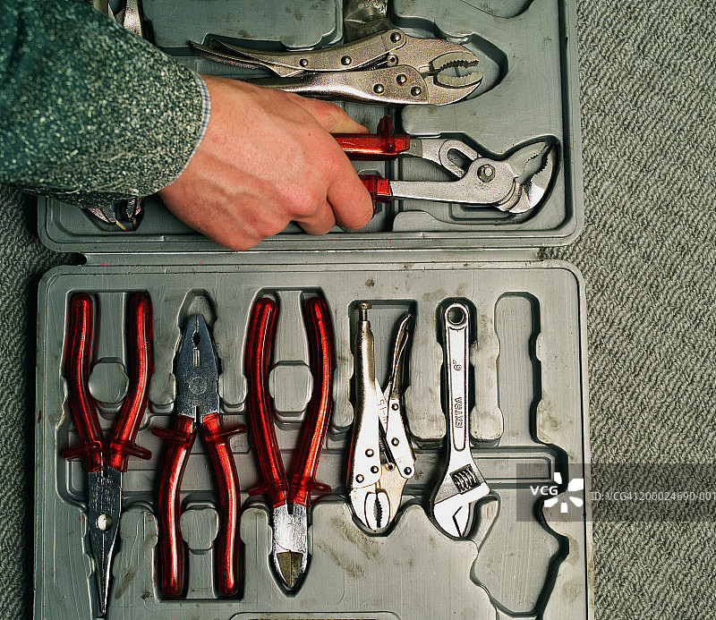男人从工具箱中取出钳子，特写图片素材