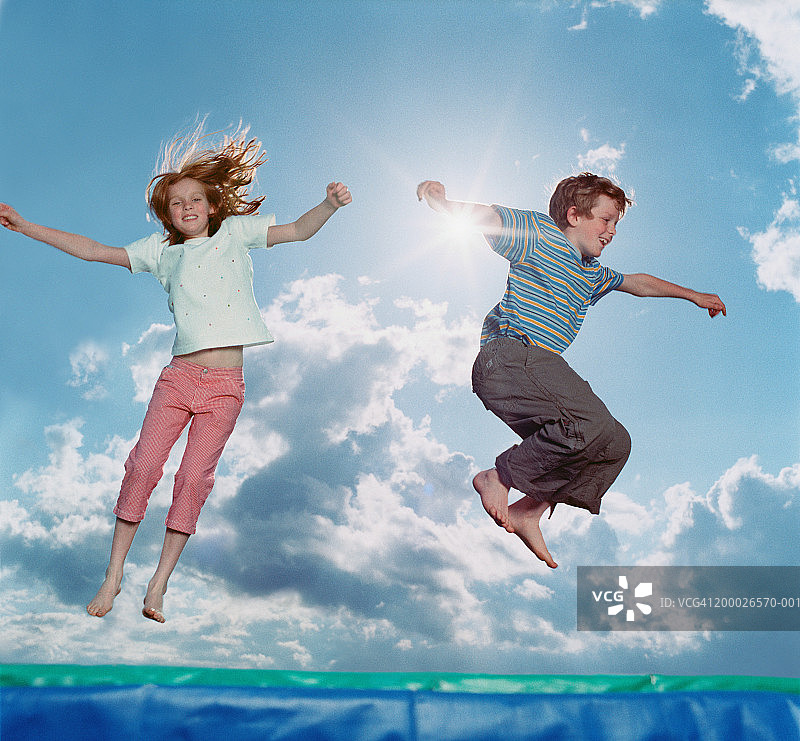 在蹦床上跳跃的男孩和女孩图片素材