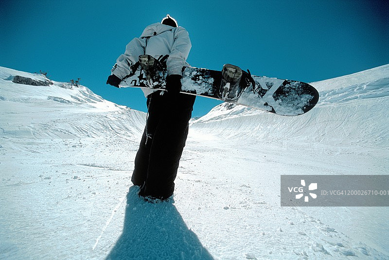 法国阿沃里亚兹：男子手持单板滑雪板，背影图片素材