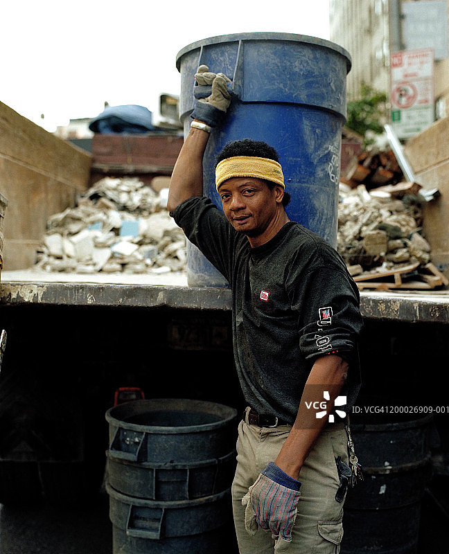 建筑工人站在装满碎石的卡车后方图片素材