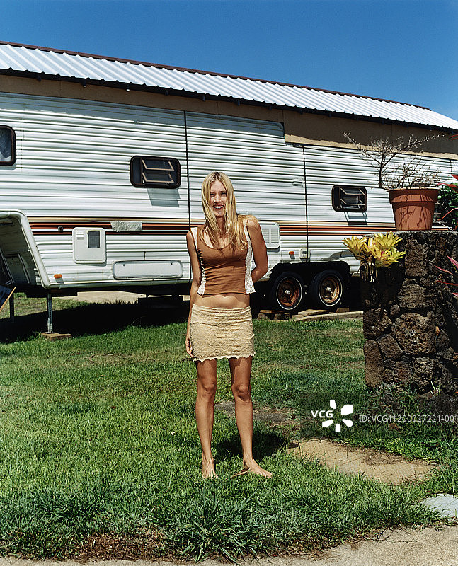 站在移动房屋外的年轻女子肖像图片素材