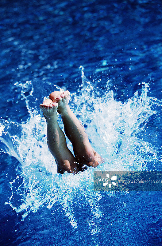年轻男人跳入水中，低角度仰视图片素材
