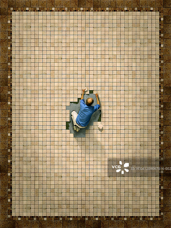 瓷砖工人在大型地板图案中心进行收尾工作（俯视）图片素材